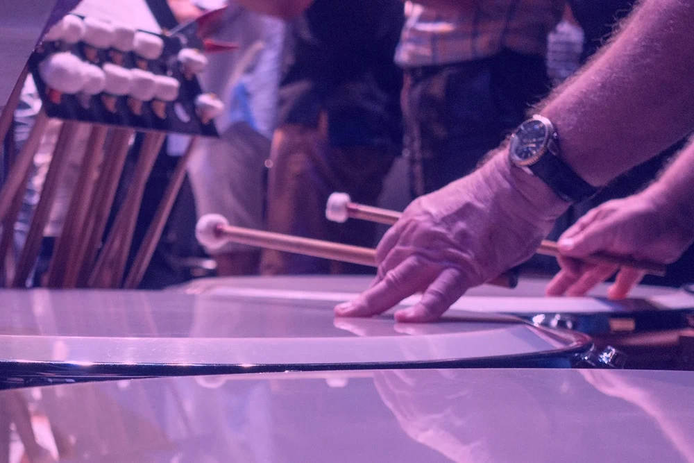 A close-up of a Symphony timpanist's hands and mallets in performance