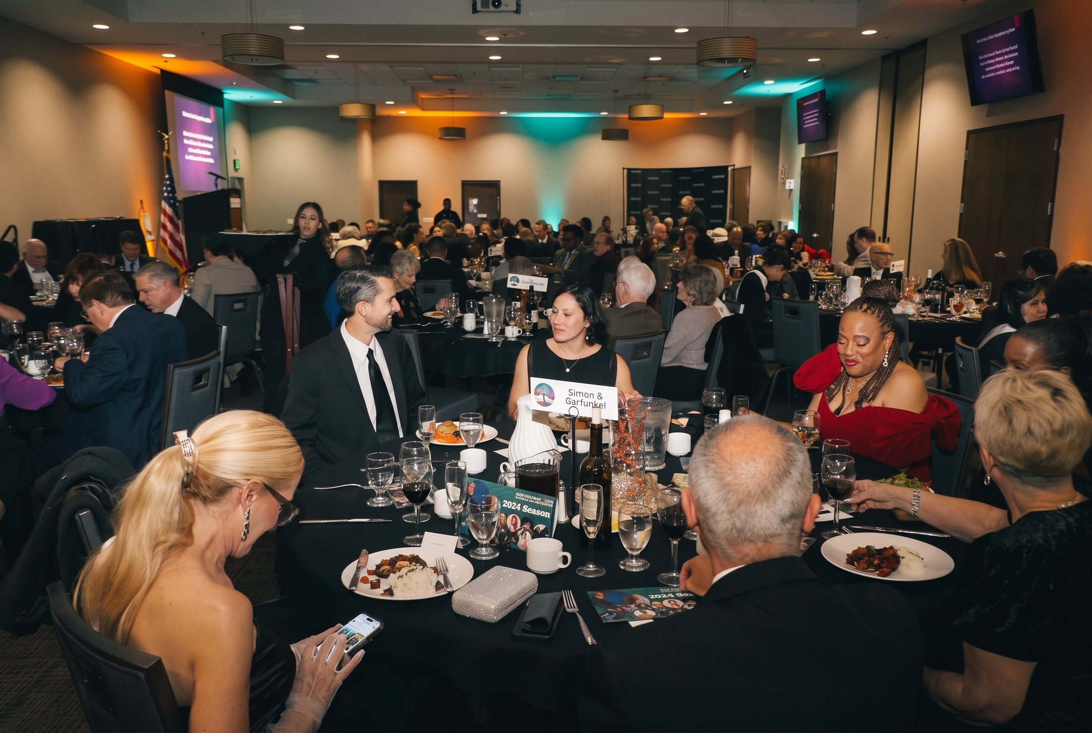 Guests dining in the teal-lit ballroom
